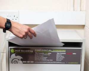 Documents being placed inside DGD Shredding confidential shredding console